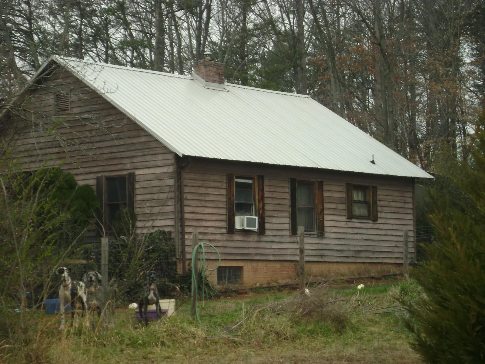 White metal roof on an old wood sided farmhouse, from a Asphalt Shingle Roof Repair job in Clinton